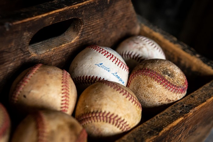 Old baseballs in a wooden crate