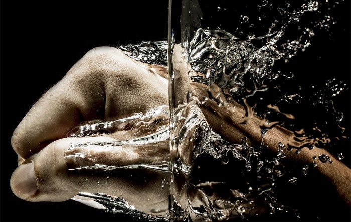 Fist punching through water splash