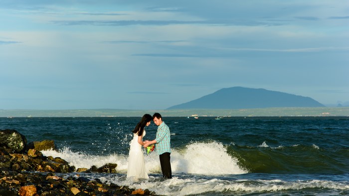 Bride and Groom on a rocky coast with waves