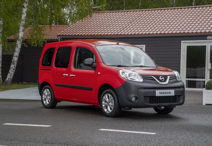 Red Nissan NV250 Combi parked outside a building