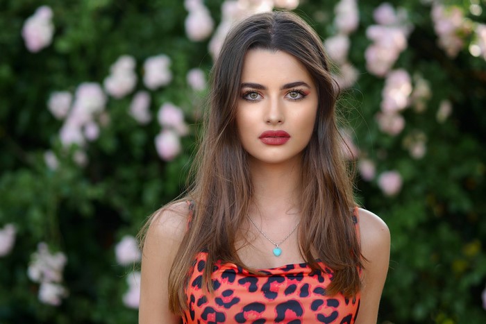 Woman with brown hair and leopard print dress