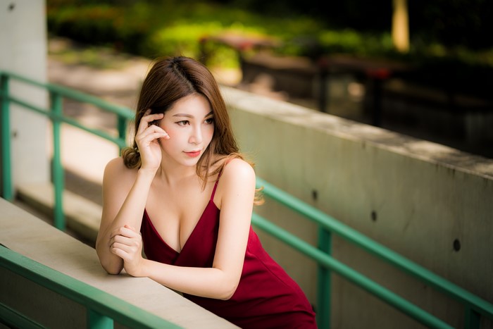 Elegant Asian Woman in Red Dress with Bokeh