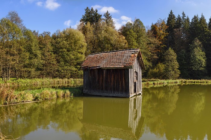 Wooden boathouse on a lake in autumn forest, Burgwalden, Germany