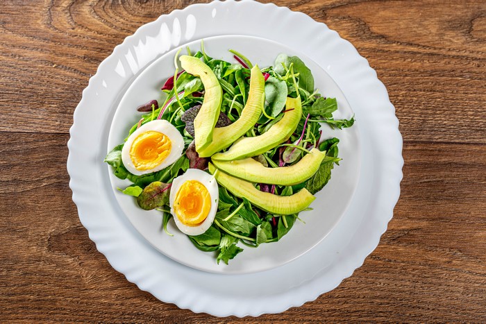 Salad with boiled eggs and avocado on a plate