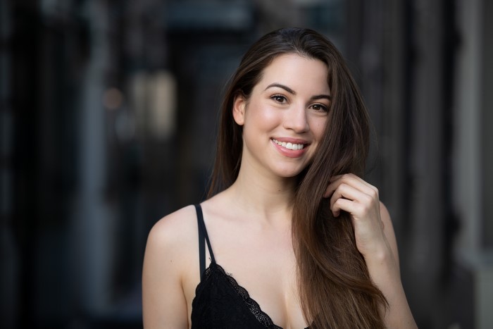 Brown haired woman smiling with bokeh background