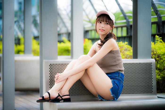 Young Woman in Baseball Cap Sitting on Bench 4K
