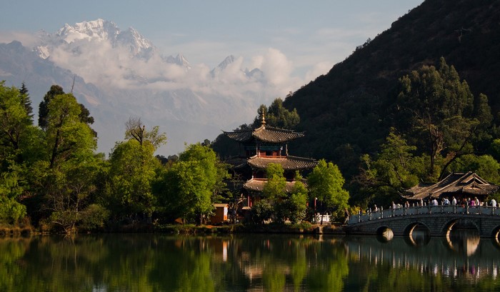 Pagoda and bridge over lake with snowy mountains in Lijiang, China
