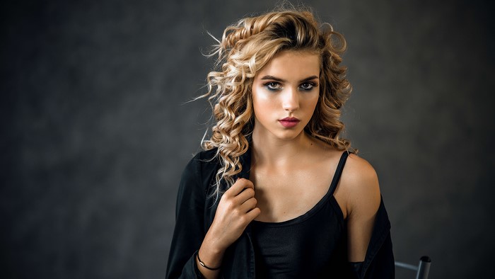 Beautiful blonde girl with curly hair and makeup