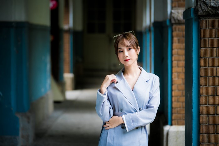 Asian woman with brown hair wearing a light blue blazer
