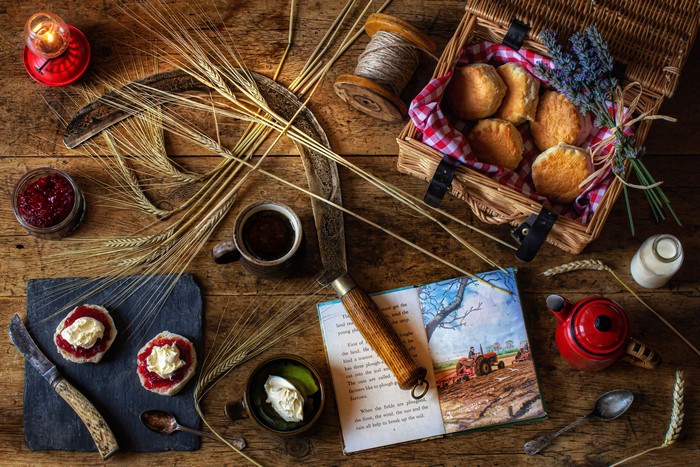 Still-life of scones, jam, coffee, and book