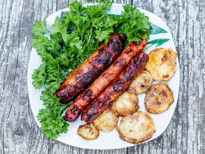 Grilled sausages with fried zucchini and parsley on a plate