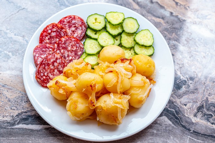 Plate of Sliced Sausage, Cucumbers, and Potatoes with Onions