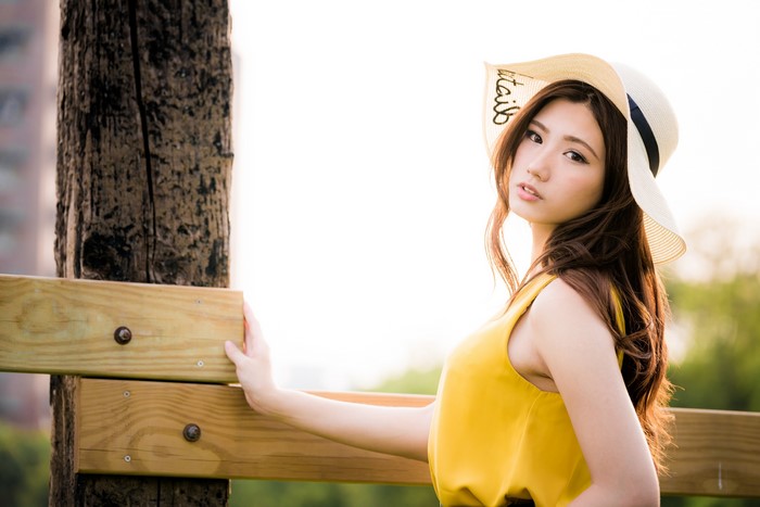 Beautiful Asian woman in a yellow dress and hat