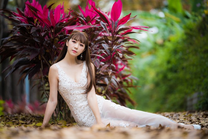 4K Elegant Woman in White Lace Dress Sitting Outdoors