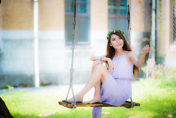 4K Cute Asian Woman Sitting on a Swing Wearing a Dress
