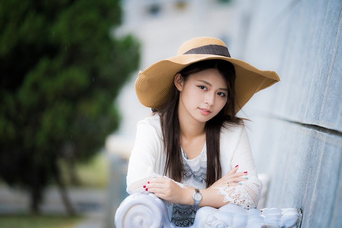 Asian woman wearing a hat and white top