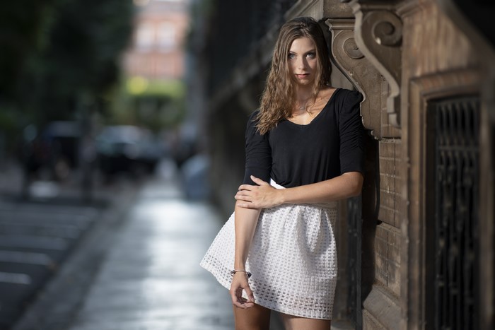 Tiffanie, a brown-haired model in a skirt, poses.