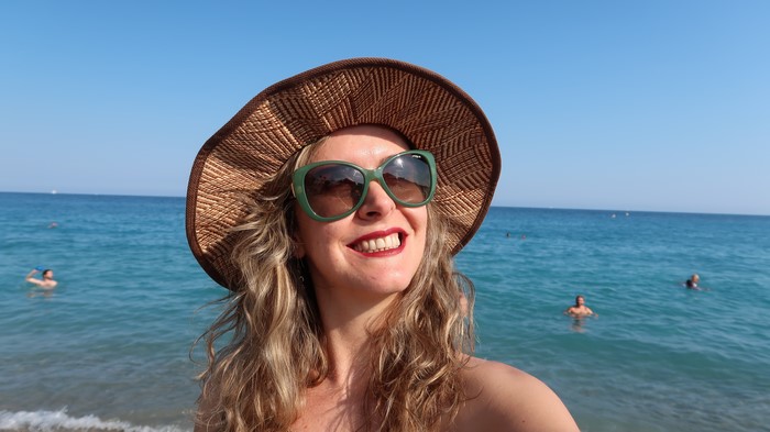 Woman in Hat and Glasses at the Sea