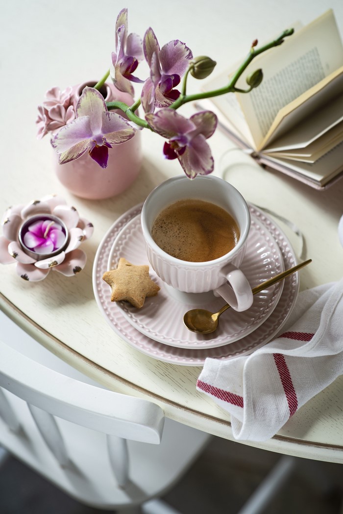Coffee cup with orchid and cookie on a saucer