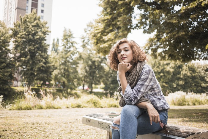 Woman Sitting on a Bench in a Park