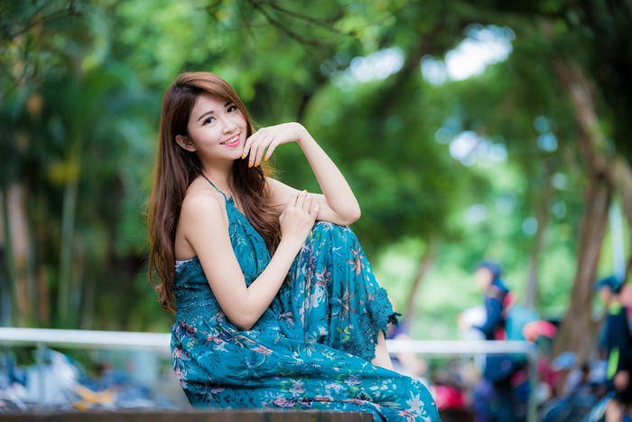 Smiling Woman in Blue Floral Dress with Bokeh