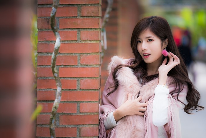 Asian girl with pink earrings and fur coat