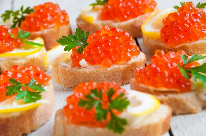 Caviar on bread with lemon and parsley