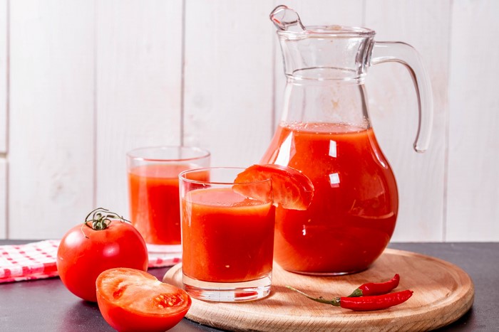 Tomato Juice in Glasses and Jug with Tomatoes and Chili Peppers