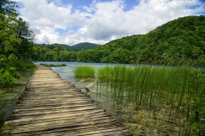 Wooden boardwalk over a clear lake in Plitvice Lakes National Park, Croatia