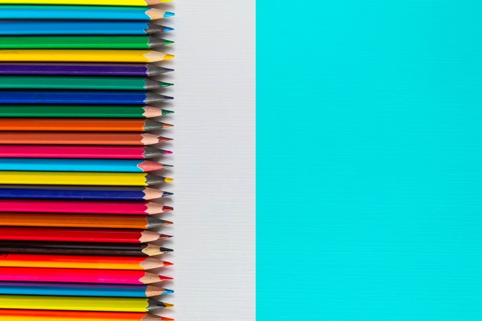 Multicolor pencils arranged on a white and blue background
