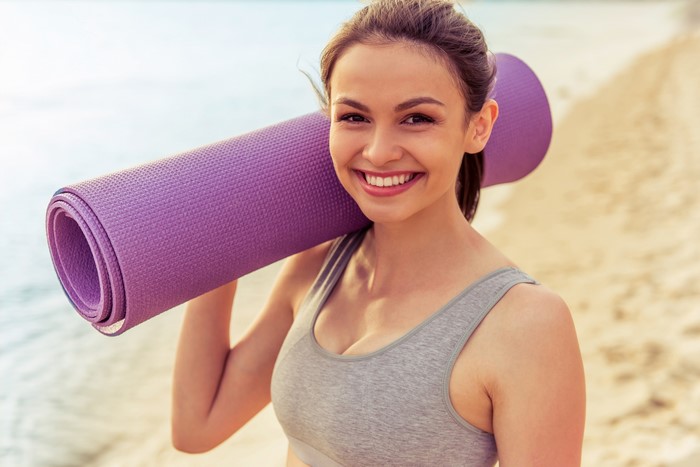 Woman with Yoga Mat on Beach