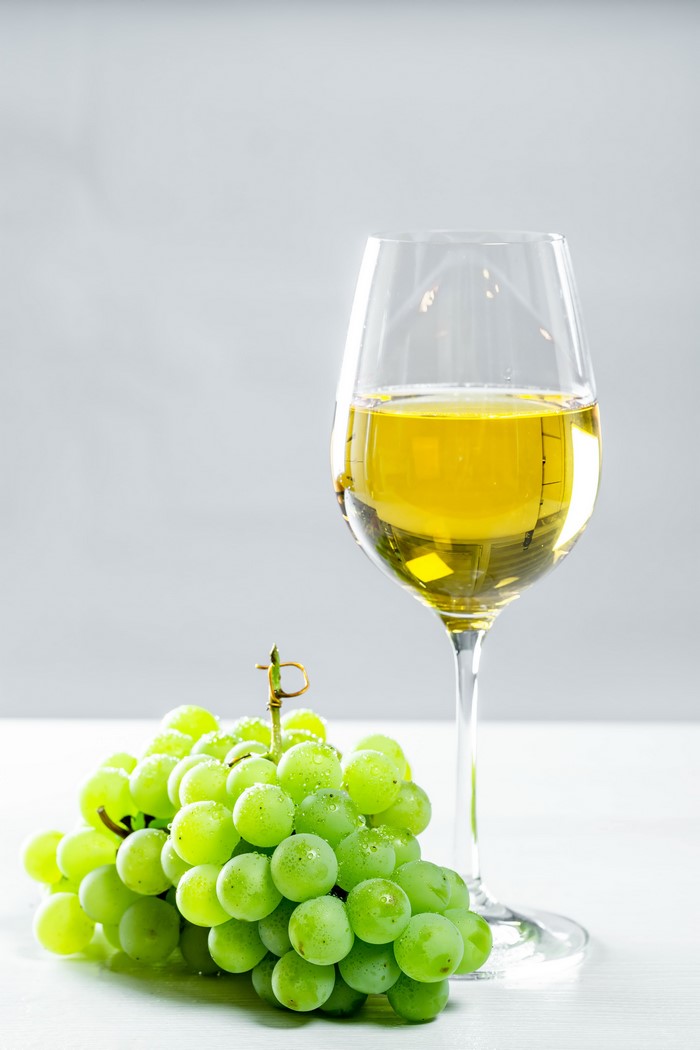 White wine in a glass with green grapes