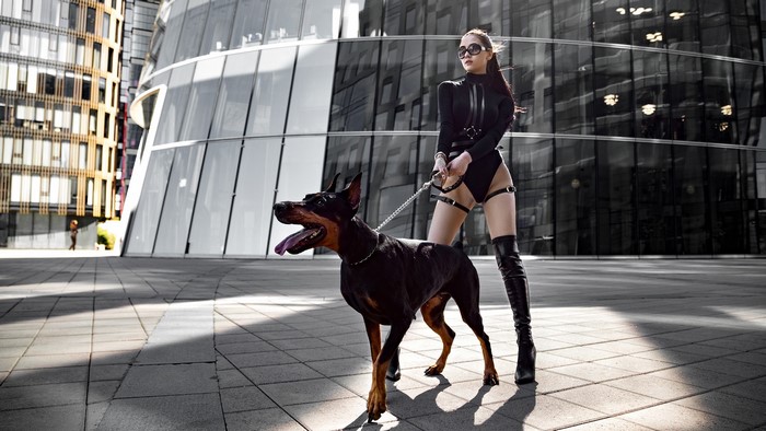 Woman in black bodysuit with Doberman Pinscher
