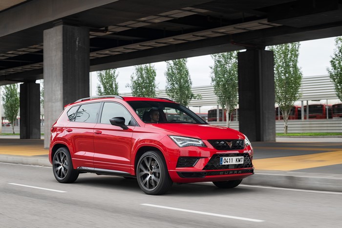 Red Cupra Ateca driving on a road