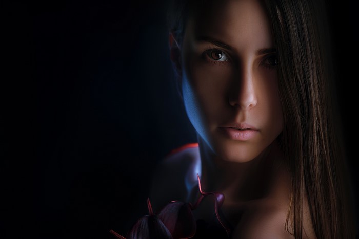 Portrait of a woman with dark hair and a flower