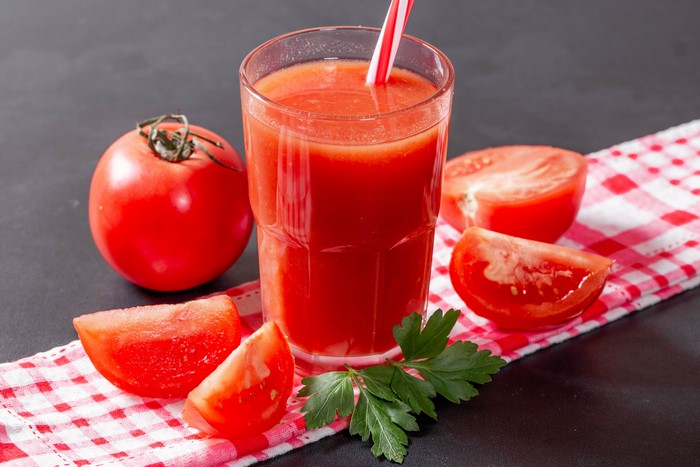 Tomato juice in a glass with tomatoes