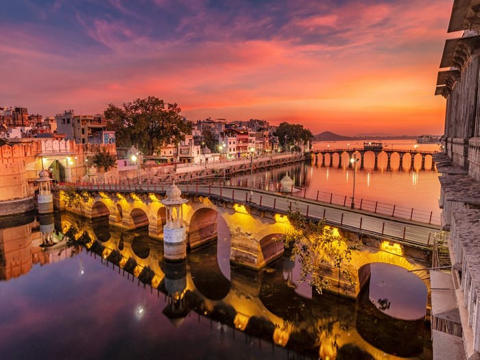 Bridge over water in Udaipur, India at sunset