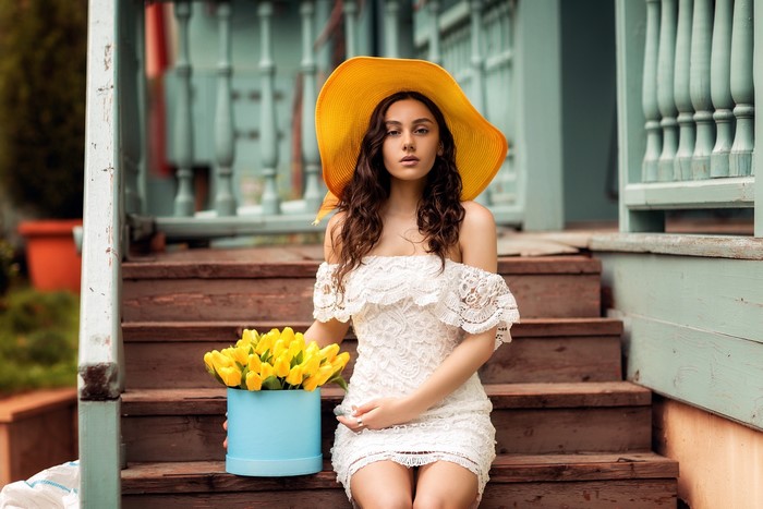 Natia Gachava sitting on stairs with yellow tulips