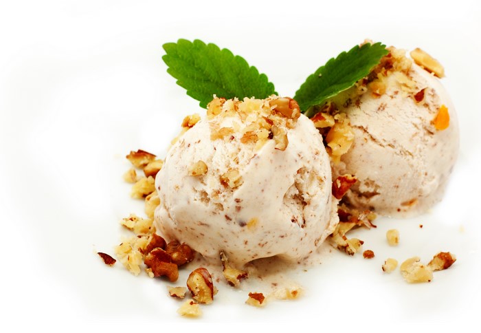 Two scoops of ice cream with nuts and mint leaves