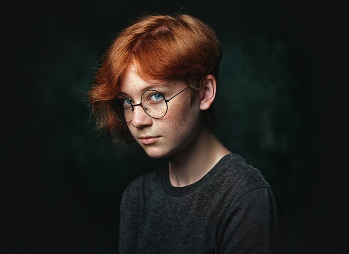 Redhead girl with glasses looking at the camera