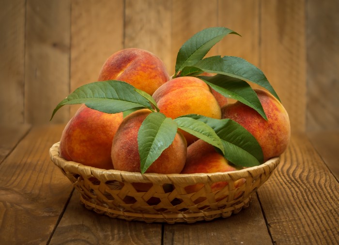 Peaches in a Wicker Basket with Foliage