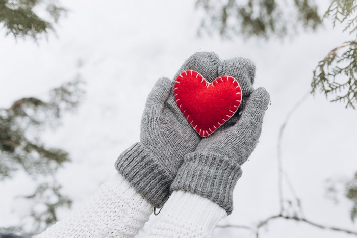 Hands holding a red heart in winter