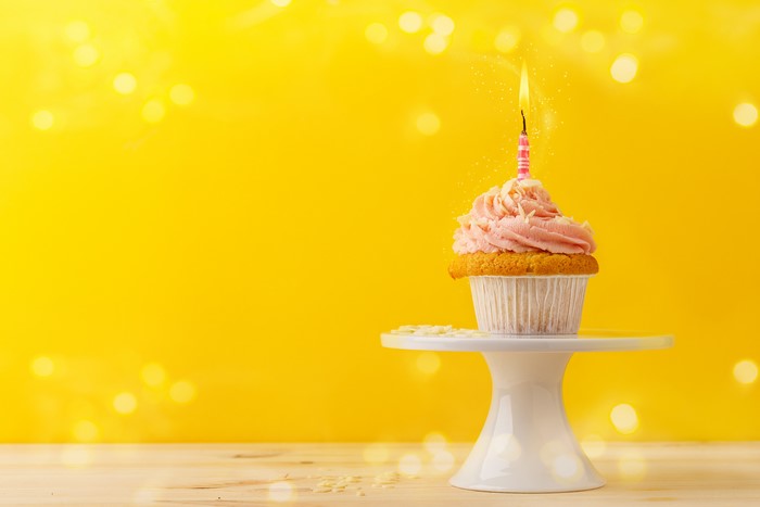 Cupcake with a lit candle on a stand