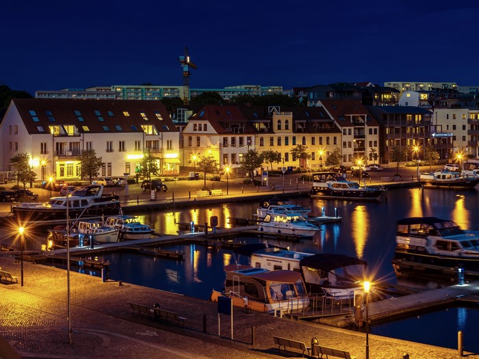 Marina with boats and buildings at night in Waren, Germany