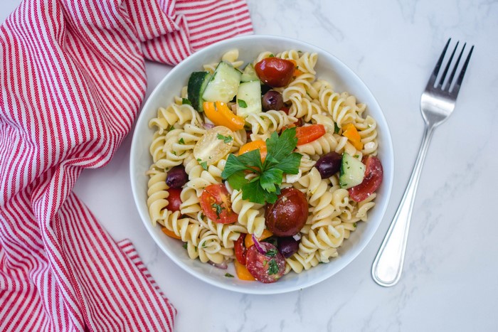 Pasta salad with tomatoes, cucumbers, olives, and bell peppers