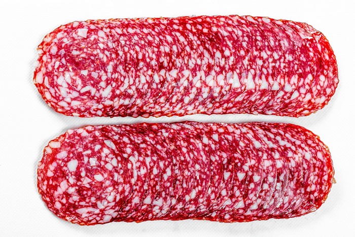 Sliced Salami Sausage on White Background