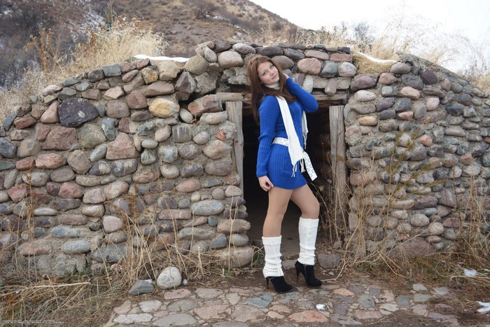 Woman in Blue Dress Posing by Stone Hut