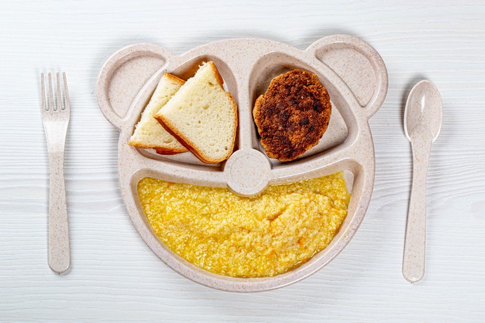 Bear-shaped plate with breakfast: bread, patty, and porridge
