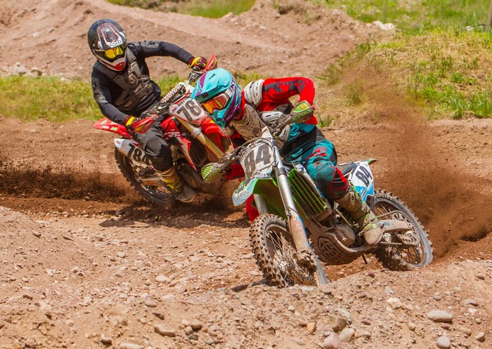 Two motocross riders racing on a dirt track
