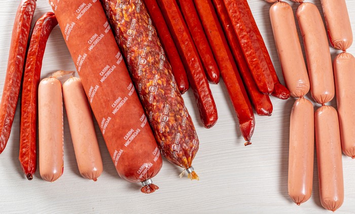 Assortment of sausages and Vienna sausages on a white surface
